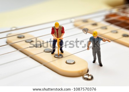 Miniature Workers Fixing The Electric Guitar Pickups