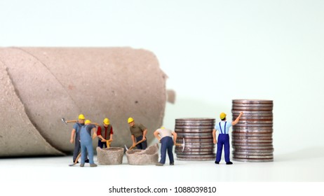 Miniature Workers Working And Piles Of Coins. Minimum Wage Improvement Demand Concept.