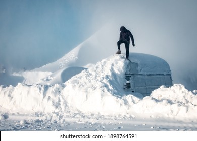 Minibus In The Snow. A Man Stands On The Roof Of A Minibus In The Snow. Consequences Of Heavy Snowfall. Concept Of Snowy Weather, Snowfall, Bad Winter Weather Conditions, The Effects Of A Blizzard.