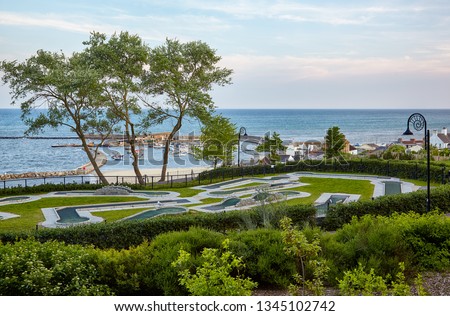 The mini-golf field in the Seafront gardens (Langmoor and Lister Gardens) with the beautiful view of Cobb harbor of Lyme Regis. West Dorset. England