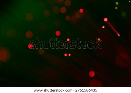 Minimal abstract composition of red glowing particles on a dark green background, representing digital signals, data points, and modern technology.