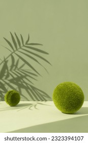 Minimal abstract scene with grass balls and the shadow of palm leaves on a green background. Premium empty podium for product promotion, beauty, natural eco cosmetic. Showcase, display case