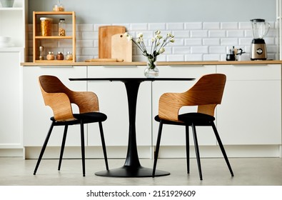 Minimal background image of black kitchen table set with two wooden chairs, copy space