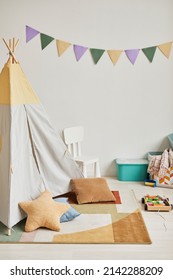 Minimal background image of cute kids room interior with play tent and decor in pastel colors