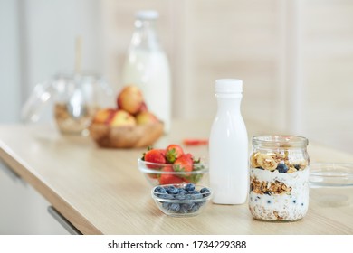 Minimal background image of healthy granola dessert with yogurt on kitchen table, copy space - Shutterstock ID 1734229388