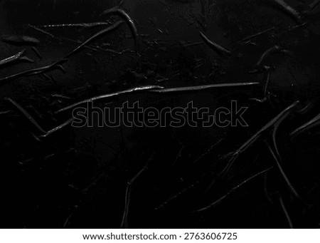 A minimal black plastic texture featuring fine wrinkles and thin reflective highlights, ideal for moody, modern, and low-contrast background designs.