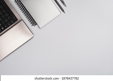 Minimaler geschäftlicher Hintergrund. Arbeitstisch mit Laptop und Bürobedarf auf grauem Hintergrund. Stilvoller Arbeitsbereich in trendiger Farbe. Draufsicht, flache Lage, Kopienraum