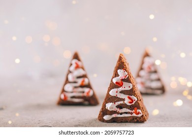 Minimal Christmas Card. Christmas trees on light background with garland lights. Food Christmas concept. Copy space