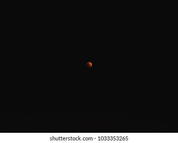 Minimal compose of full red moon on black dark night sky.