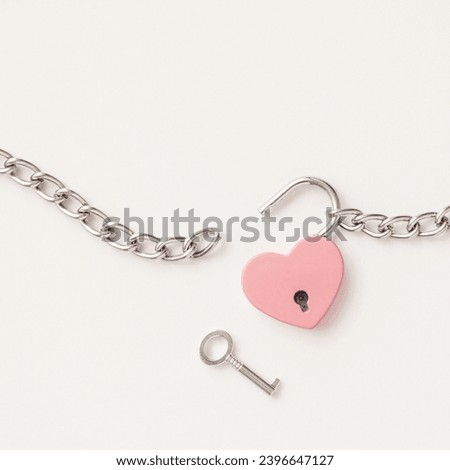 Minimal concept of Breaking up a love relationship. Family divorce. Family happiness. The pink heart is tied with a chain and a padlock. Love concept.