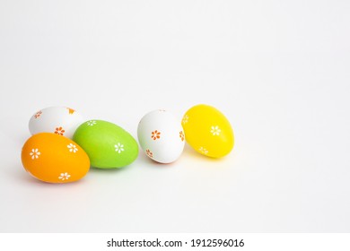 The minimal concept of Easter colour eggs. Stylish Easter eggs on a white background. The fashionable Easter lay flat. Happy Easter Greeting card with copy space for text. High quality photo