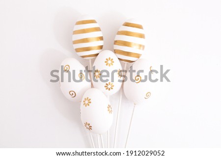 The minimal concept of Easter golden eggs. Stylish Easter golden eggs on a white background. The fashionable Easter lay flat. Happy Easter Greeting card with copy space for text. High quality photo