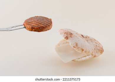 Minimal Concept Of Fast Food Cravings. Grilled Veggie Burger And Open Mouth Made With Sliced Flatbread Bun And Cheese Tongue. Isolated Pastel White Background. Delicious Gourmet Barbecue Food Idea.