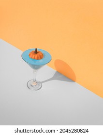 A minimal concept for Halloween with a glass of pumpkin and champagne filled with color. Creative background of holiday fun - Shutterstock ID 2045280824