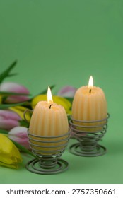 Minimal Easter background with egg candles and tulips on clean light background with space for text