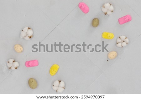 Minimal Easter flat lay with speckled eggs, cotton, pink and yellow peeps on pastel background.