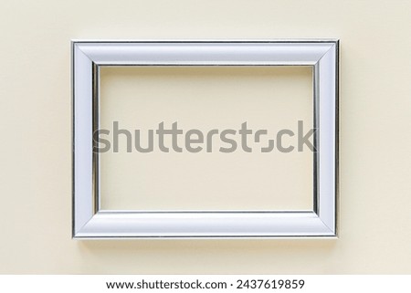 Minimal empty rectangular white frame picture mock up hanging on light beige wall