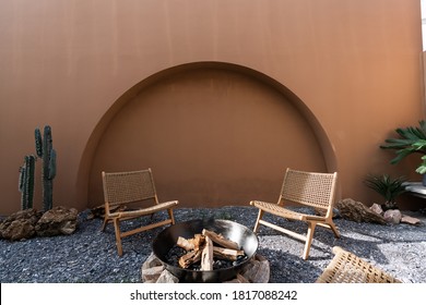 Minimal empty space scene with brown painted wall and  rattan armchair and artificial cactus with rock setting  in natural light scene / studio concept / tropical theme / outdoor studio - Shutterstock ID 1817088242