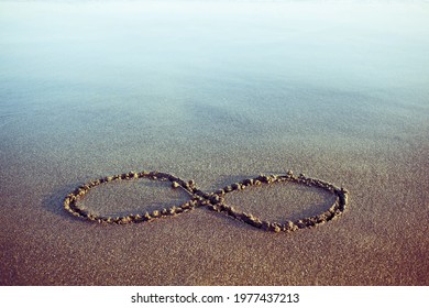 Minimal eternity and infinity symbol hand drawn on a sand - Shutterstock ID 1977437213