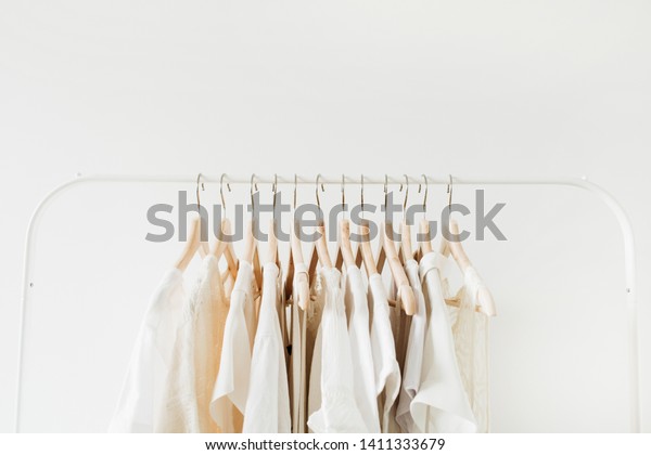 Minimal fashion clothes concept. Female blouses\
and t-shirts on hanger on white background. Fashion blog, website,\
social media hero\
header.