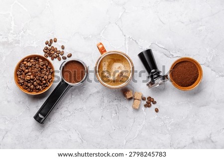 Minimal flat lay with roasted coffee beans, espresso tools and tamper on marble surface