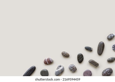 Minimal flat lay with sea pebble stones on beige background with copy space. Natural smooth stone black color. Summer concept, top view, empty space - Shutterstock ID 2169594459
