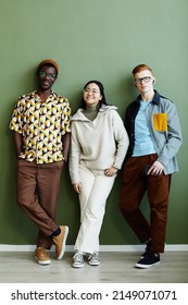 Minimal Full Length Portrait Of Diverse Creative Team Looking At Camera While Standing Against Green Wall