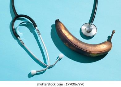 Minimal layout with a rotten banana and a traditional stethoscope with hard shadows - Powered by Shutterstock