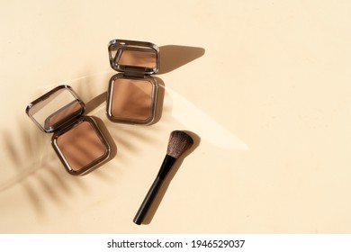 Minimal modern cosmetic scene with make up brushe, bronzer and palm shadow overlay, top view with copy space