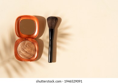 Minimal modern cosmetic scene with make up brushes, bronzer and shadow overlay, copy space