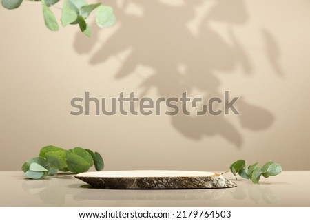 Minimal modern product display on neutral beige background. Wood slice podium and green leaves. Concept scene stage showcase for new product, promotion sale, banner, presentation, cosmetic