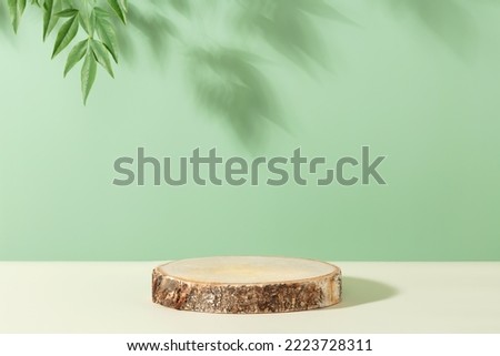 Minimal modern product display on green background. Wood slice podium and green leaves. Concept scene stage showcase for new product, promotion sale, banner, presentation, cosmetic
