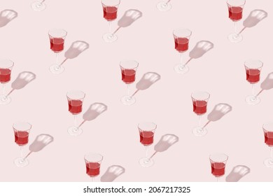 Minimal Pattern Made Of Wine Glasses With Red Wine Isolated On Pastel Pink Background. Drink For Party, Wine Shop Or Wine Tasting Concept. Sun, Shadows And Reflections. Summer Mediterranean Texture. 