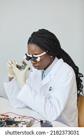 Minimal Portrait Of Black Female Engineer Inspecting Electronic Parts In Laboratory
