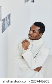 Minimal Portrait Of Handsome Black Man Looking At Images In Photo Gallery And Enjoying Art