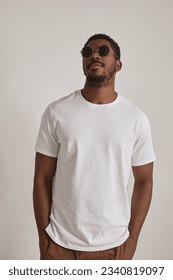 Minimal portrait of handsome black man wearing sunglasses and posing confidently in studio against white background - Shutterstock ID 2340819097