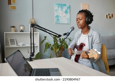 Minimal Portrait Of Young Black Woman Singing To Microphone And Playing Guitar At Home Recording Studio, Copy Space