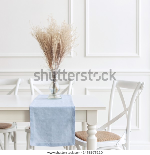 Minimal Scandinavian decor. Linen table runner and\
flowers on table.