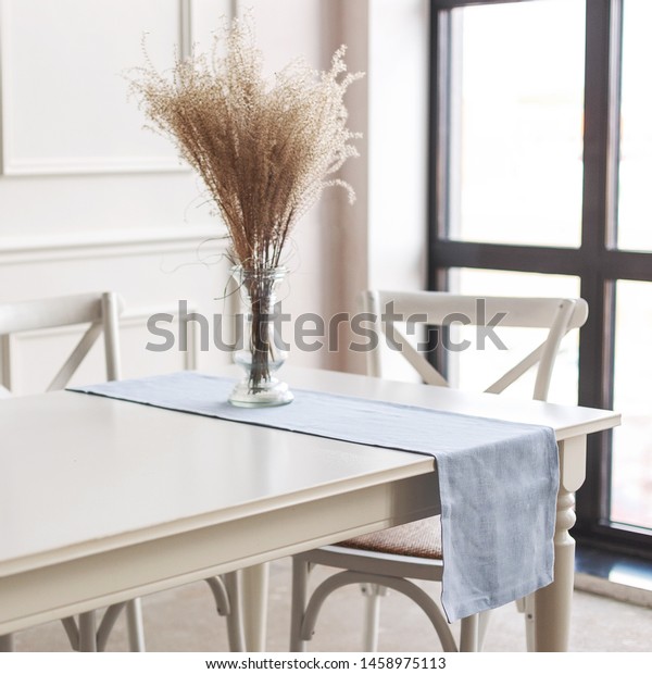 Minimal Scandinavian decor. Linen table runner and
flowers on table.