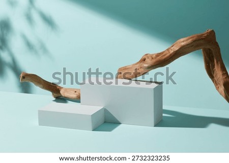 Minimal scene with a white rectangular podium and curved wooden branch on pastel blue background, designed for clean product placement and modern branding layouts