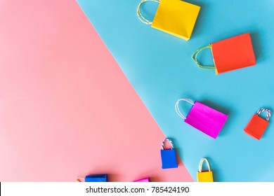 Minimal Shopping Online Concept, Colorful Paper Shopping Bag Go Down From Floating Pink And Blue Background For Copy Space. Customer Can Buy Everything Form Home And The Messenger Will Deliver.