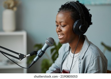 Minimal Side View Portrait Of Young Black Woman Singing To Microphone In Home Recording Studio, Copy Space