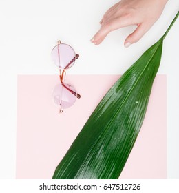 Minimal Style. Minimalist Fashion Photography. Vintage. Glamour. Pink Sunglasses With A Fresh Tropical Leaf On A Pink Pastel Background