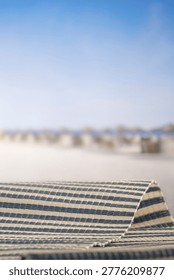 Minimal summer composition featuring clean sandy beach with empty copy space for product placement. In the background, a rocky coastline meets the sea under a bright blue sky, creating a natural and scenic atmosphere. Ideal for advertising, travel promotions, and summer lifestyle concepts.