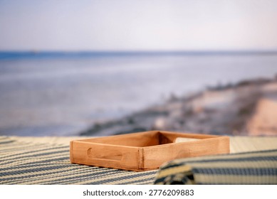 Minimal summer composition featuring clean sandy beach with empty copy space for product placement. In the background, a rocky coastline meets the sea under a bright blue sky, creating a natural and scenic atmosphere. Ideal for advertising, travel promotions, and summer lifestyle concepts.