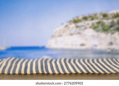 Minimal summer composition featuring clean sandy beach with empty copy space for product placement. In the background, a rocky coastline meets the sea under a bright blue sky, creating a natural and scenic atmosphere. Ideal for advertising, travel promotions, and summer lifestyle concepts.