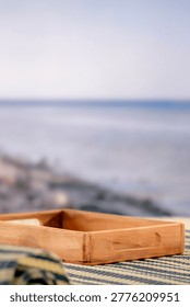 Minimal summer composition featuring clean sandy beach with empty copy space for product placement. In the background, a rocky coastline meets the sea under a bright blue sky, creating a natural and scenic atmosphere. Ideal for advertising, travel promotions, and summer lifestyle concepts.