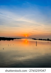 Minimal Sunset Reflection Over Smooth Water Surface.