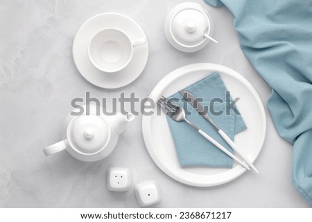 Minimal table setting with white dishes and blue napkin, elegant dining composition, real home atmosphere, soft aesthetic lifestyle, clean modern hospitality scene