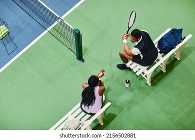 Minimal top view of two tennis players chatting during break at tennis court, copy space - Powered by Shutterstock